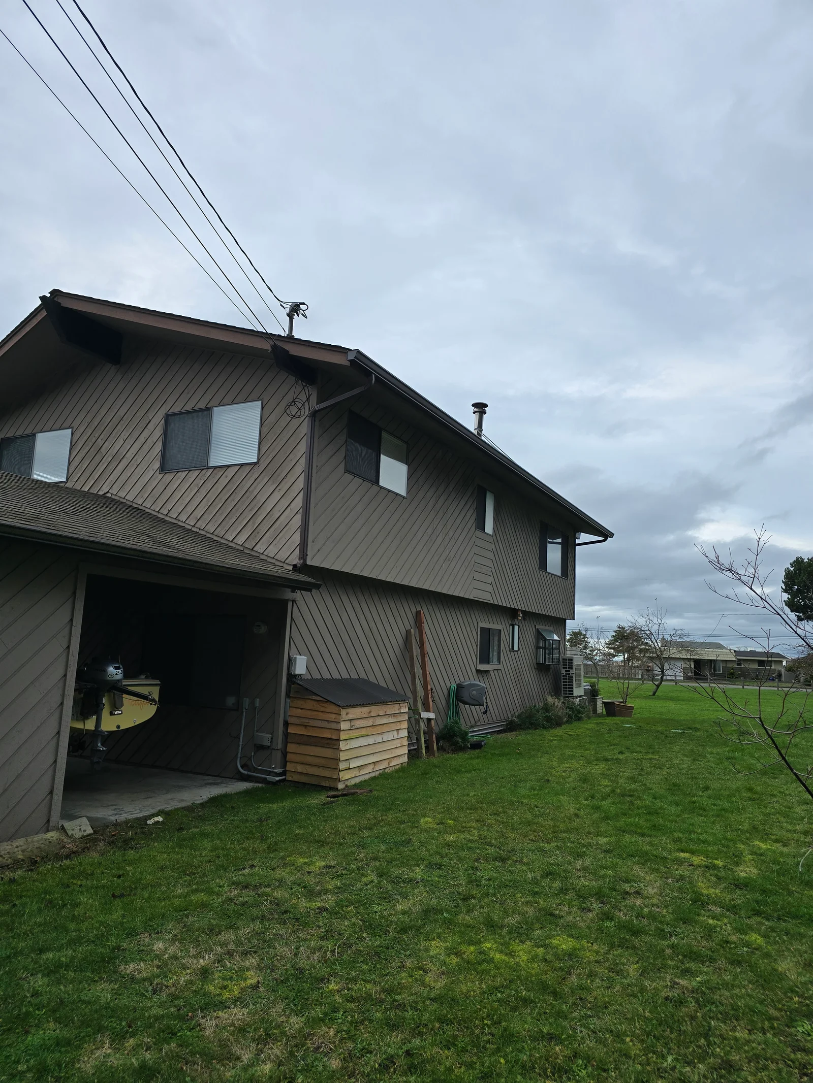 Metal gutter and downspout system installed on two-story residential home with metal siding
