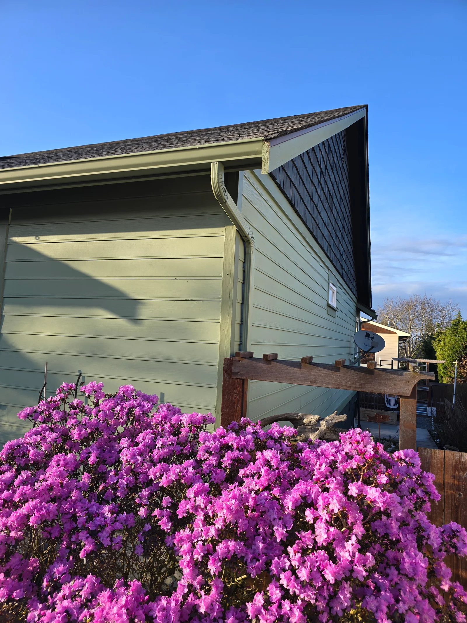 Cream aluminum seamless gutters and fascia installed on residential garage with dark shingle roof
