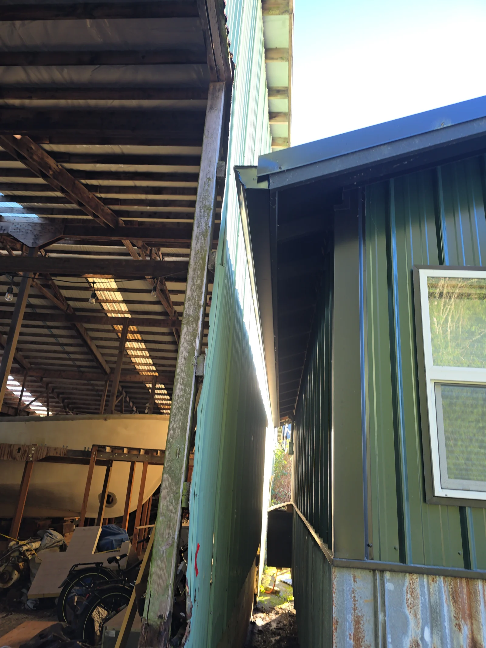 Metal gutter and downspout installation on corrugated metal-sided residential building