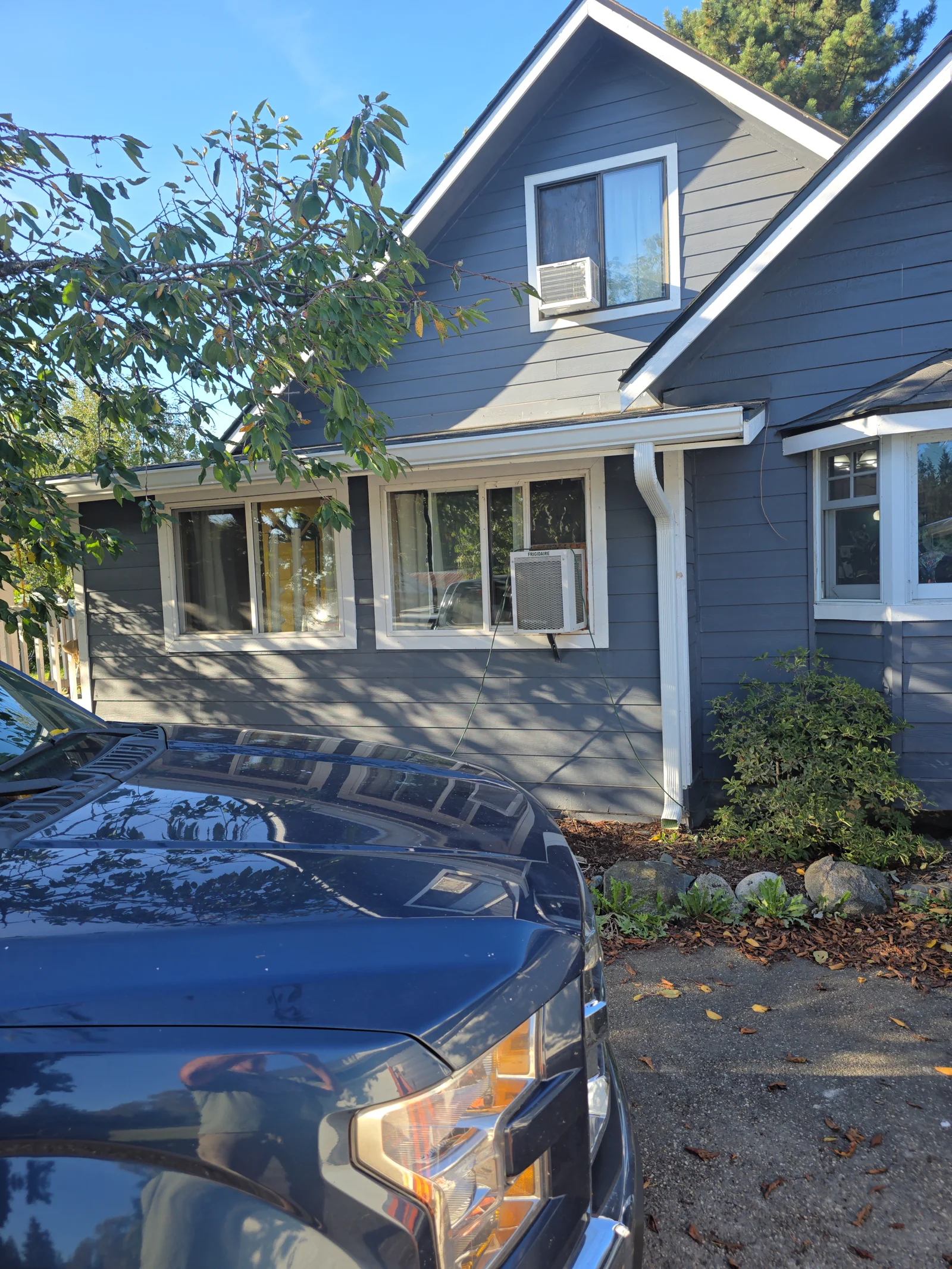 White aluminum gutters and downspouts installed on blue two-story home with white trim