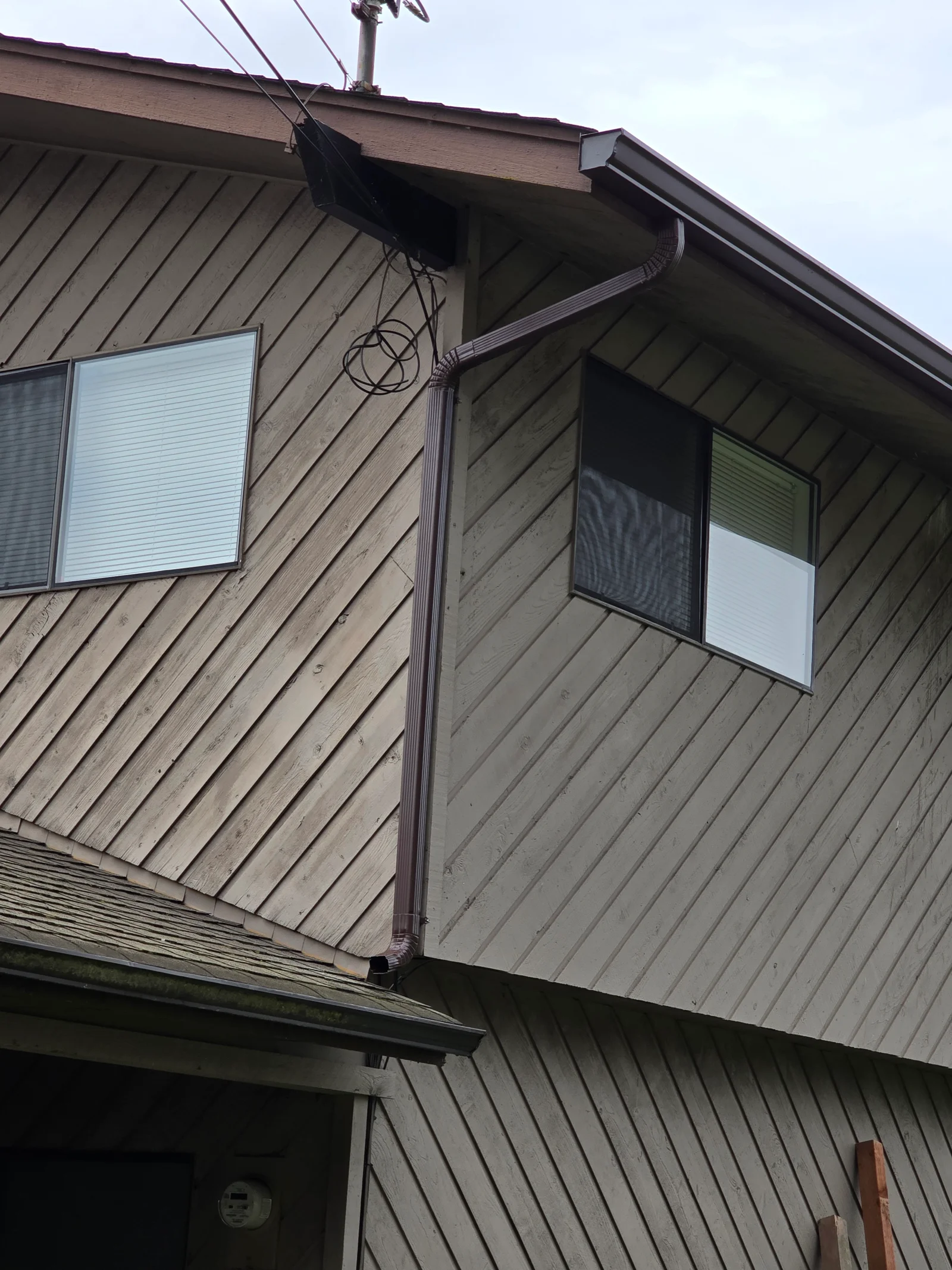 Metal gutter and downspout installed on metal-sided residential home exterior