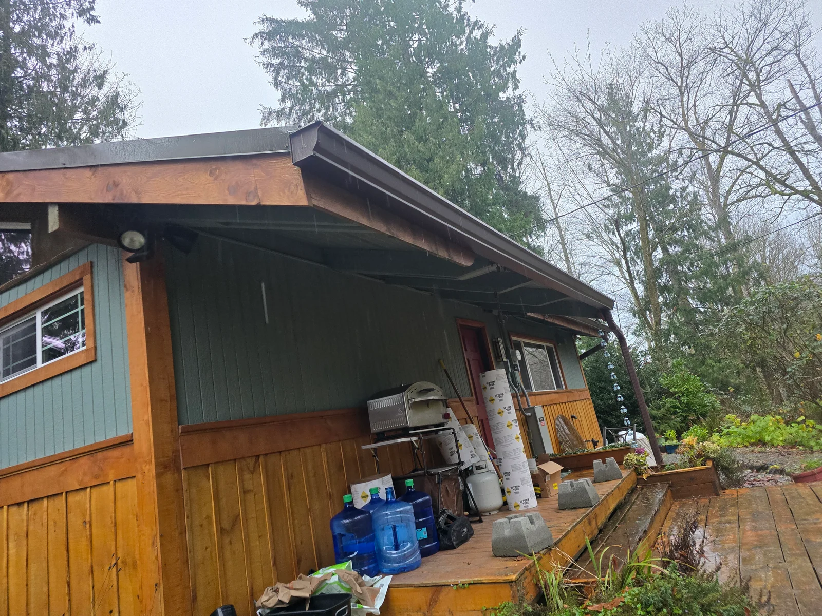Metal gutter installation with fascia board and downspout on residential home exterior